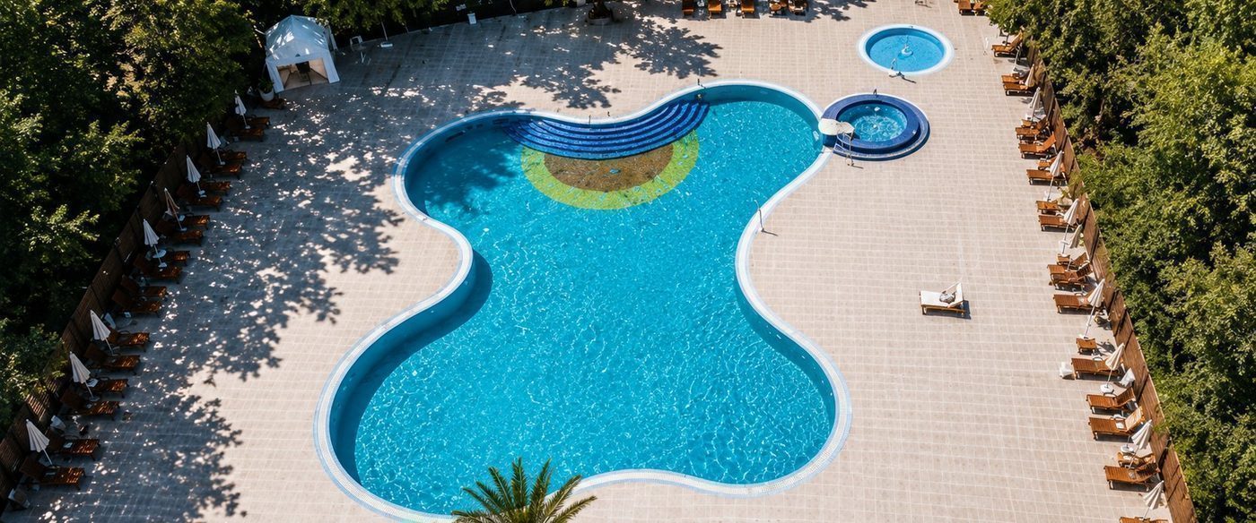 Vedere aeriană a piscinei exterioare Hotel Palas, cu șezlonguri, umbrele și bazin pentru copii