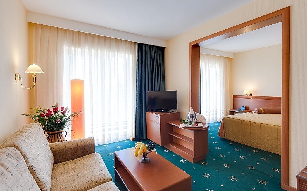 Apartament de 40 m²: livingul cu canapea și, prin deschidere, dormitorul